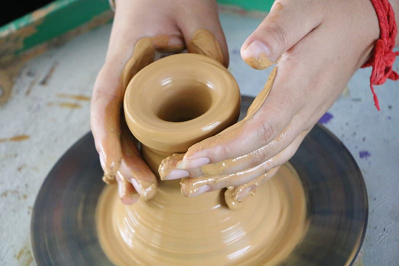 person-making-clay-pot-on-brown-clay-pot-5509141